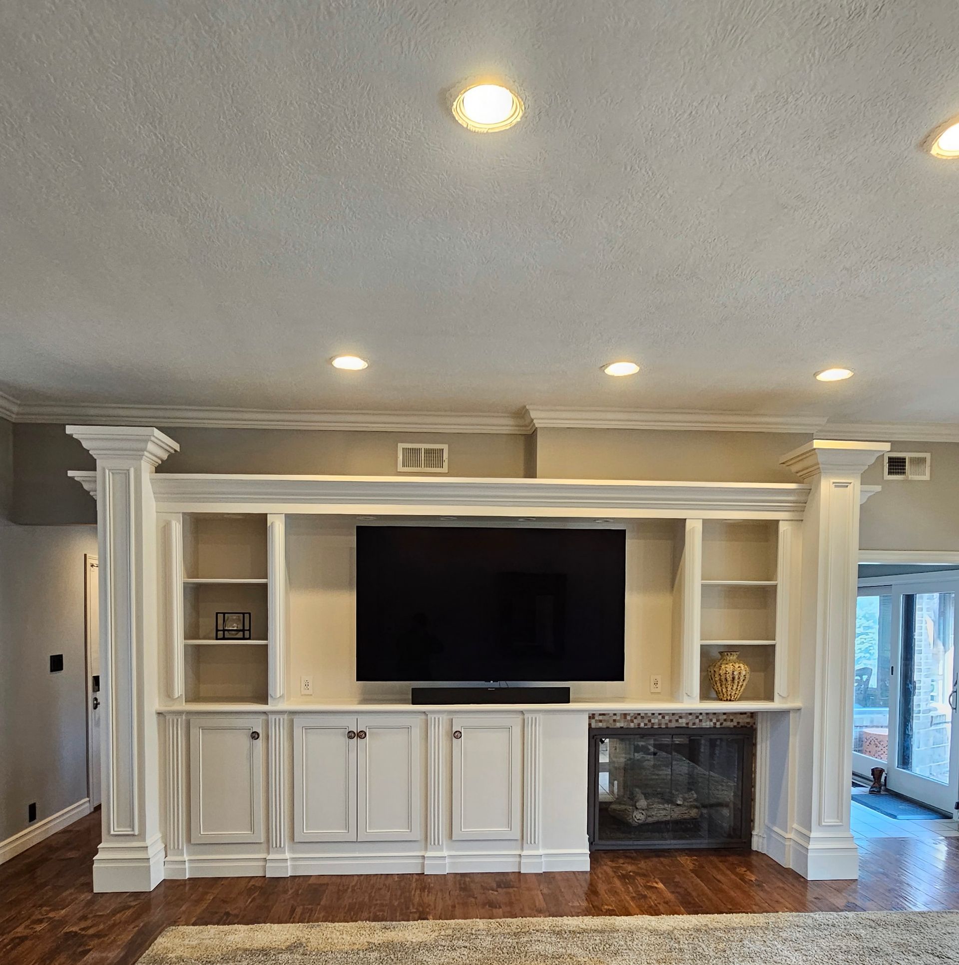 A living room with white cabinets and a flat screen tv