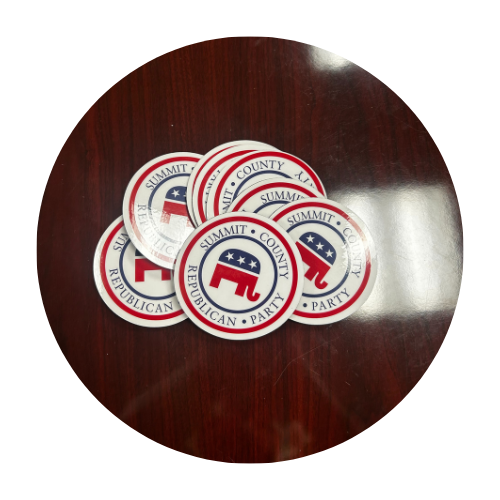 Pile of Summit County Republican Party stickers on a dark wooden surface.