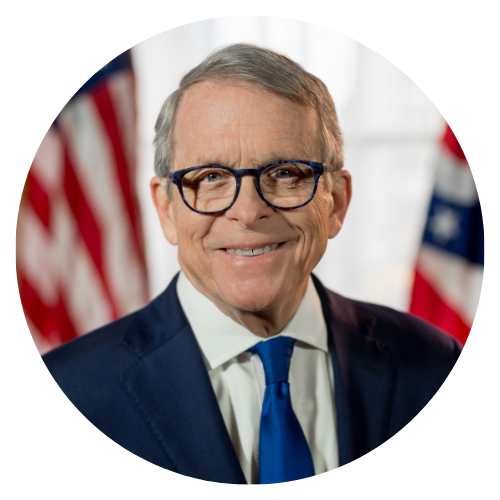 Mike DeWine, Ohio Governor, smiling, wearing glasses and a blue suit, with US flag in background.