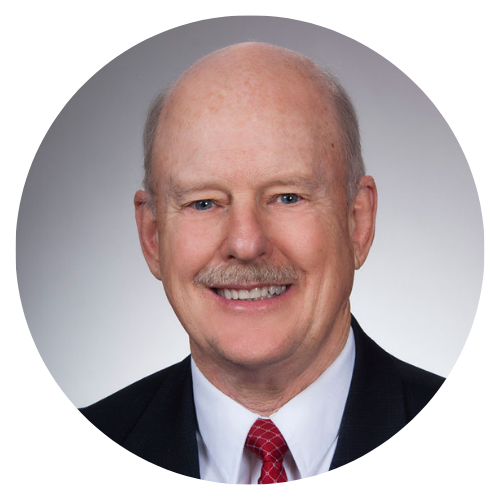 Bald man in a suit smiling at the camera.