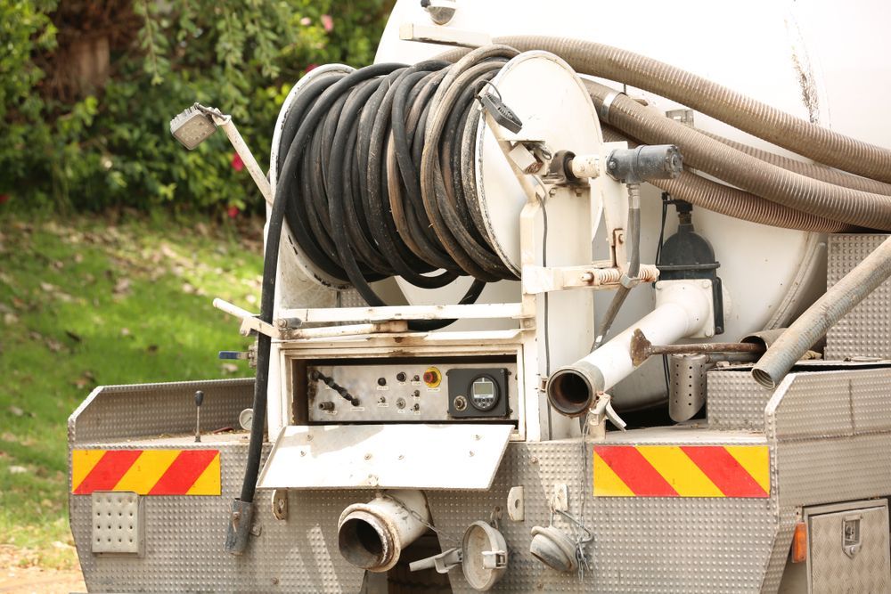 Rear of a White Sanitation Truck With a Coiled Hose Reel — Atherton Location Services In Atherton, QLD
