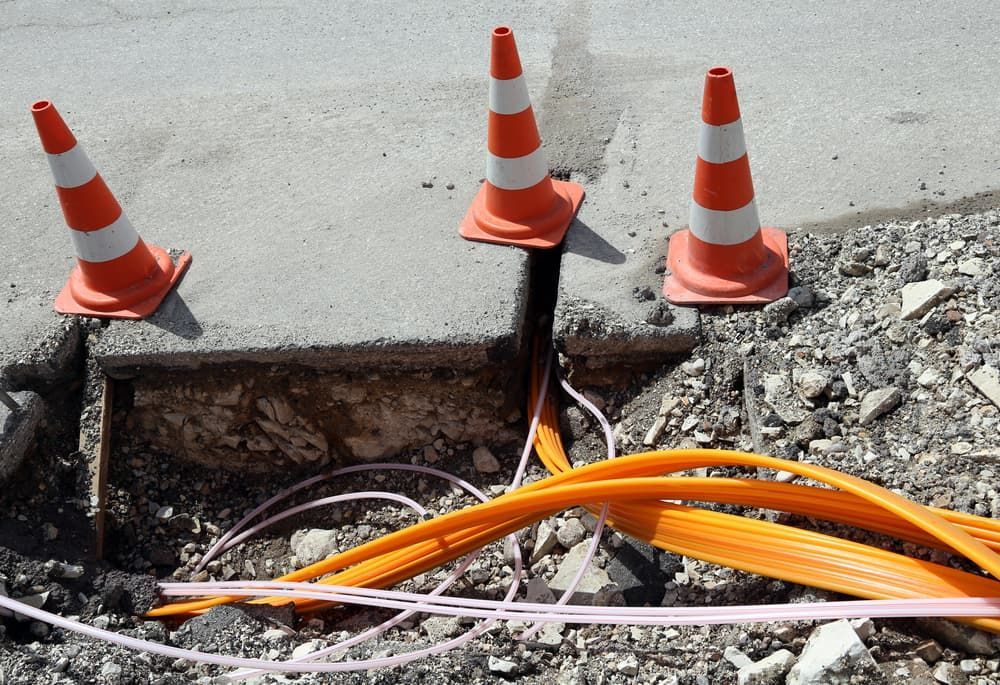 Orange Cones Around a Road Excavation — Atherton Location Services In Atherton, QLD