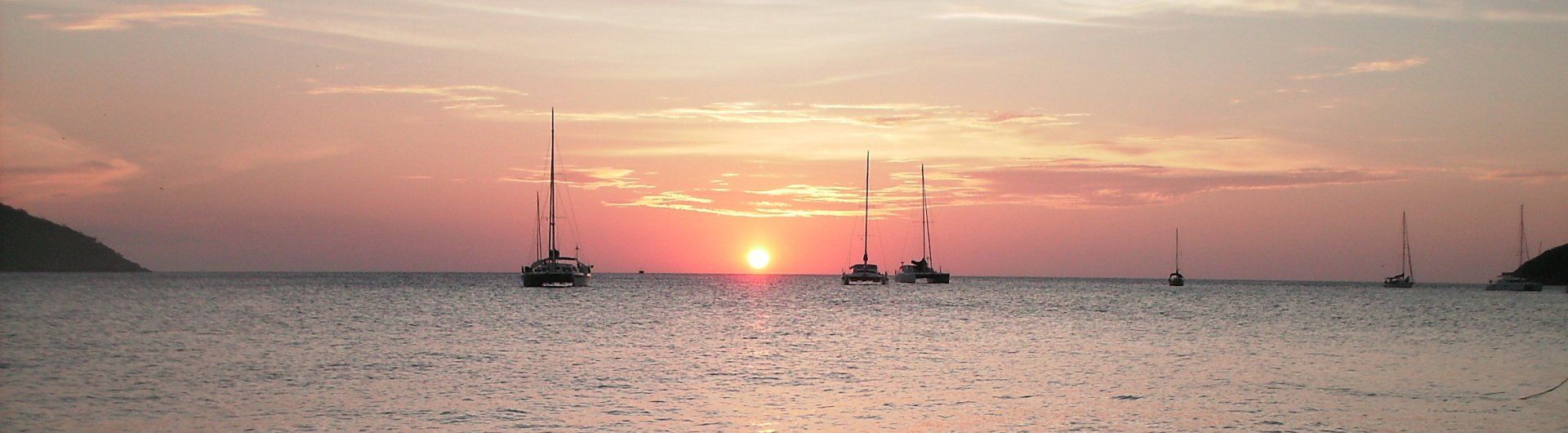 A sunset over the ocean with boats in the water