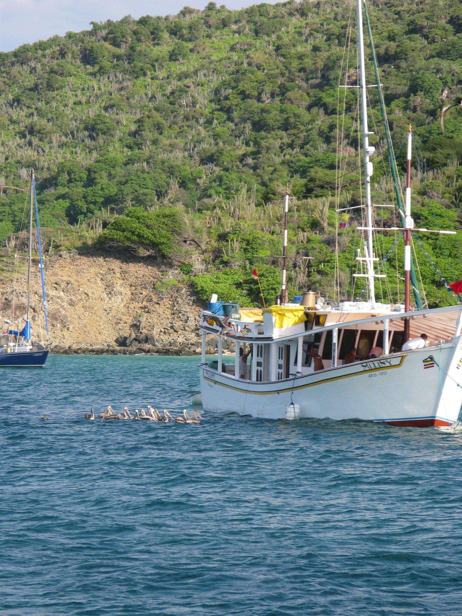 A boat with a yellow stripe on the side is in the water