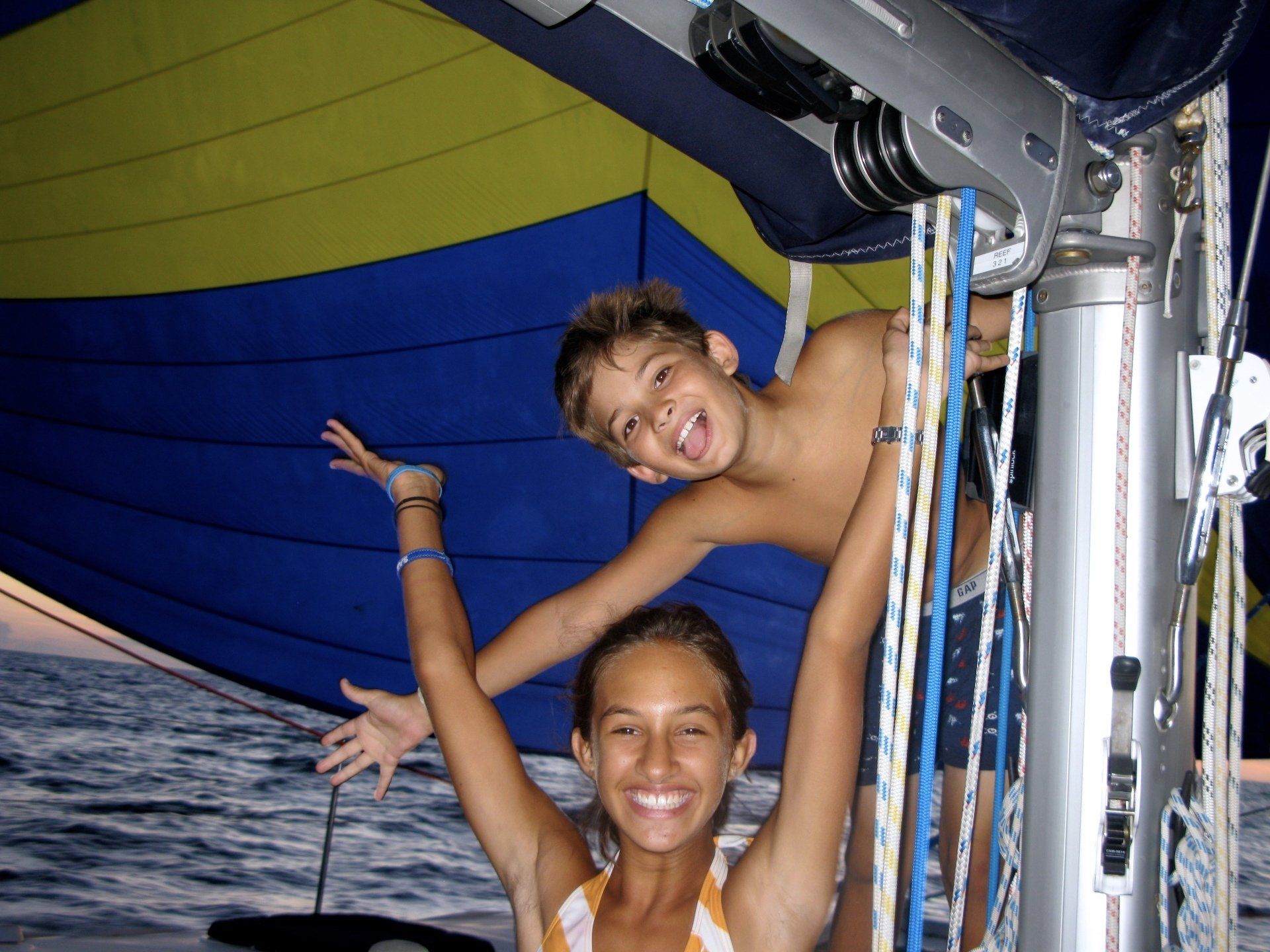 cruising kids at mast with spinnaker under sail