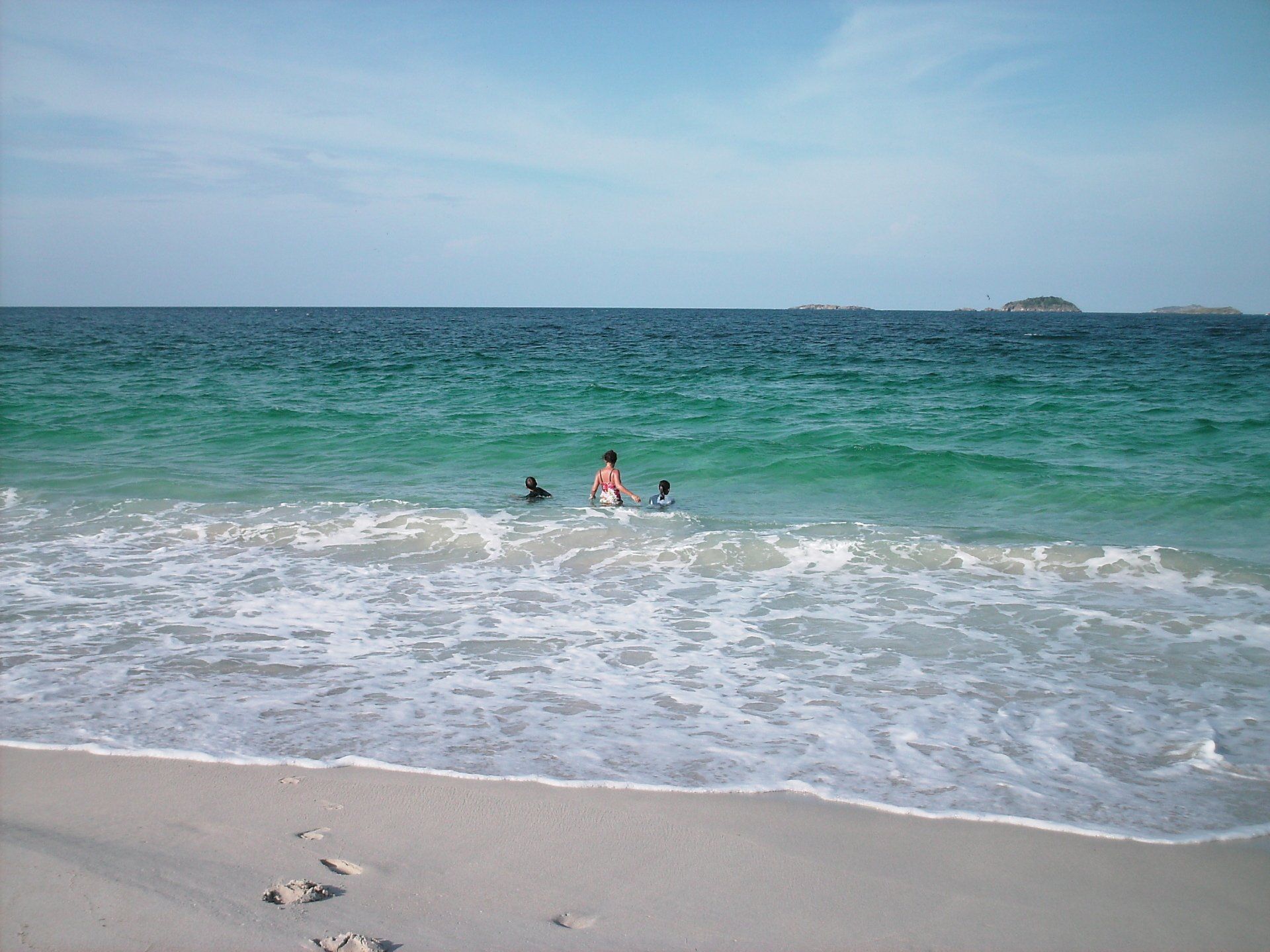 People are swimming in the ocean on a beach