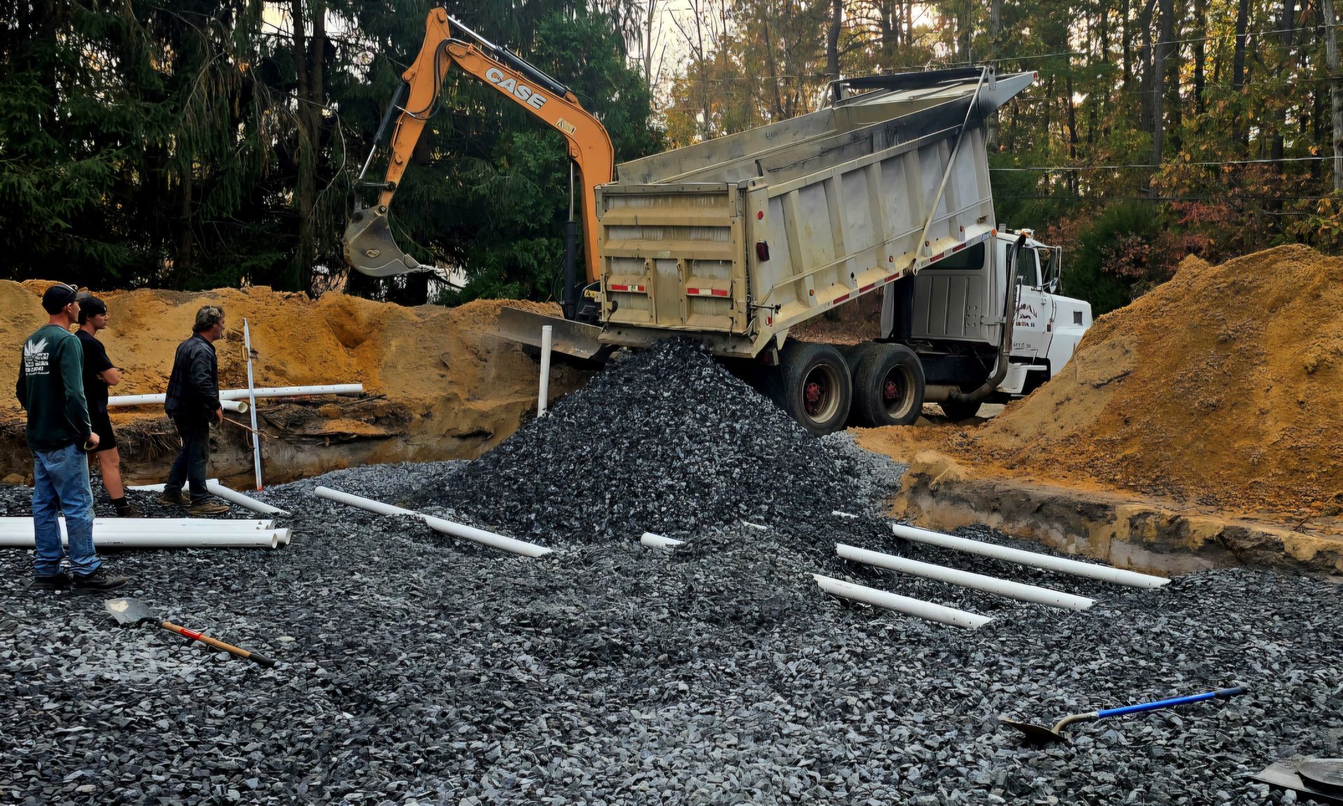 A crane is lifting a septic tank into the ground.