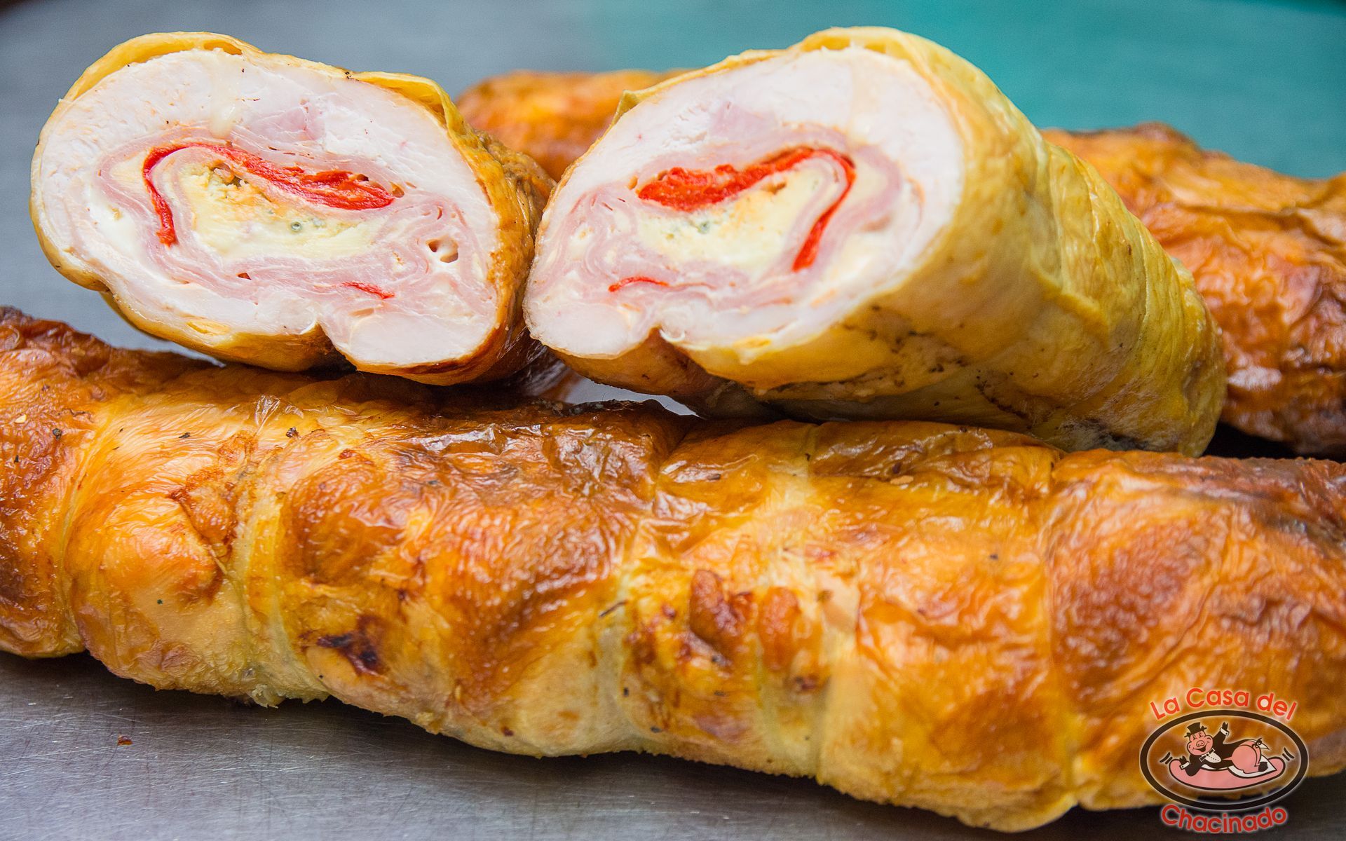 Rollitos fritos de color marrón dorado, rellenos de crema blanca y roja, apilados en un plato.