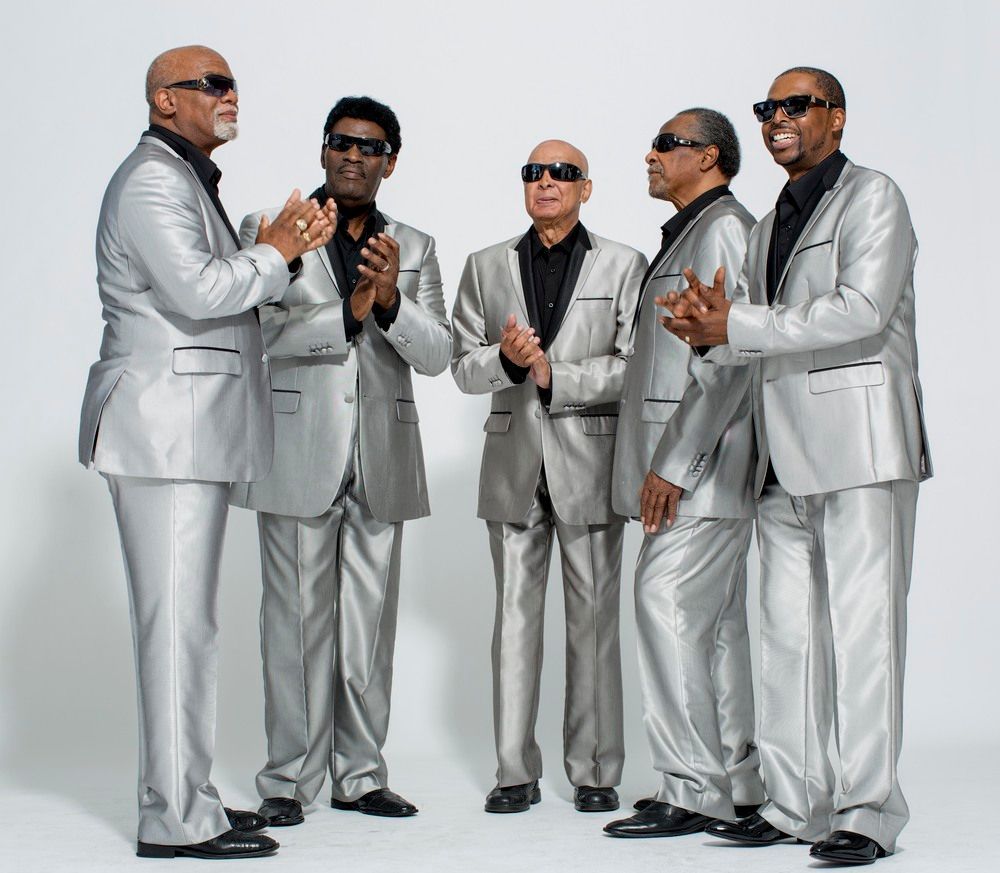 Men in silver suits clapping, standing on white background.