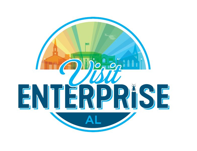 Visit Enterprise AL logo with city buildings against a colorful sky. Blue and white circles frame the text.