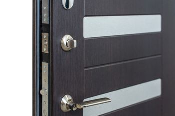 Primo piano di una moderna porta nera con maniglia e serratura argentate.