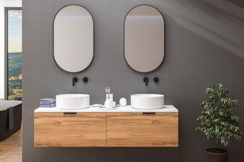 Mobile bagno moderno con due specchi rotondi, lavabi bianchi e una pianta in vaso su una parete grigia.