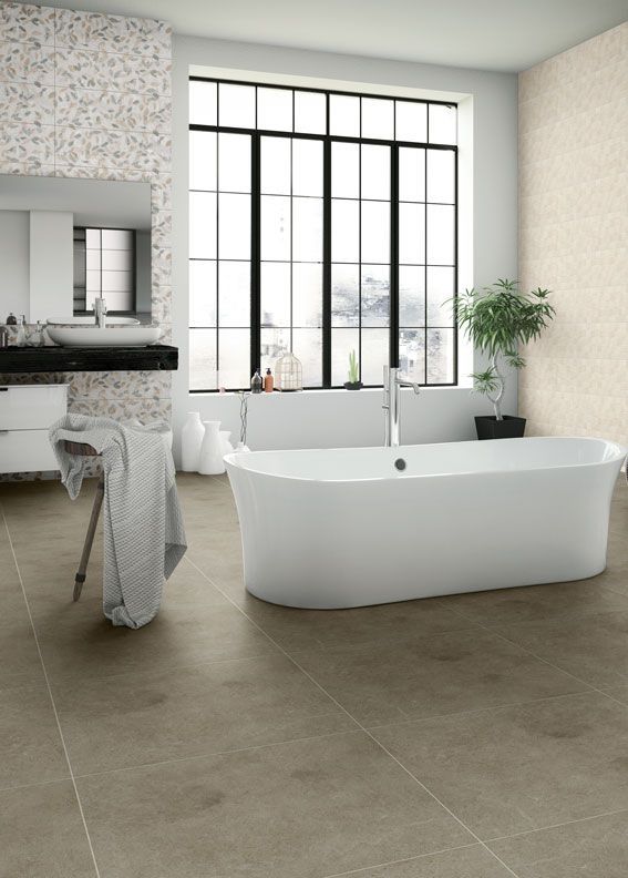 Bagno moderno con vasca freestanding, ampia finestra con cornice nera e pavimento in piastrelle grigie.