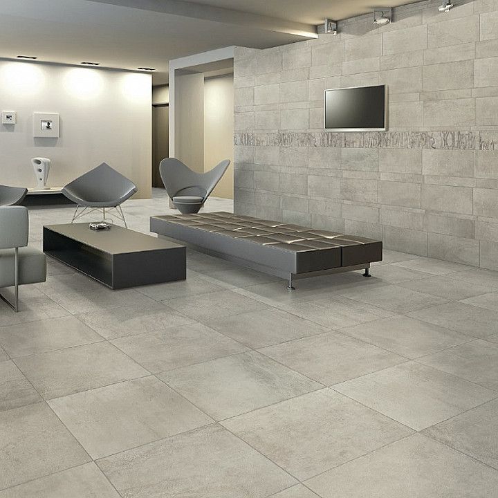 Hall moderna e minimalista con pavimento piastrellato grigio, tavolino basso nero, panche e schermo a parete.