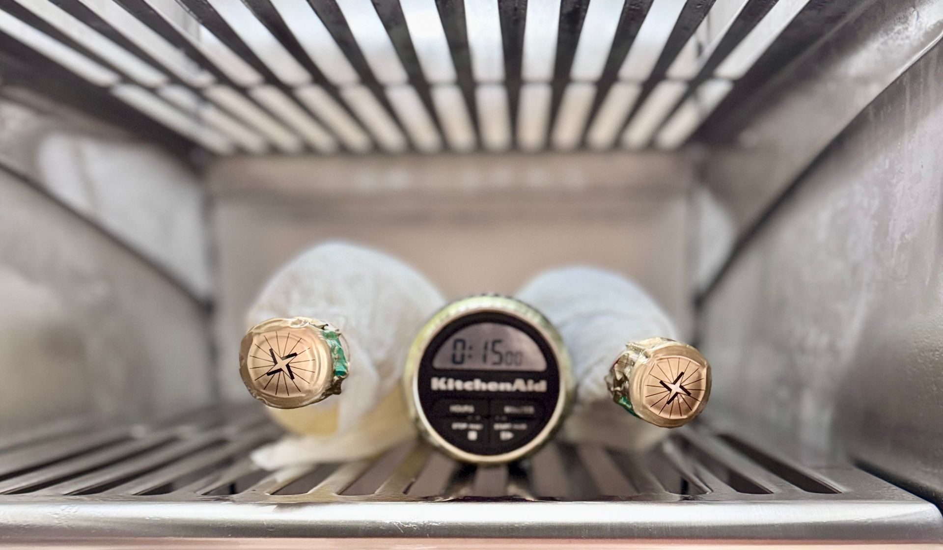 Champagne bottle wrapped in wet paper towel in the freezer with a 15 minute timer for fast chilling.