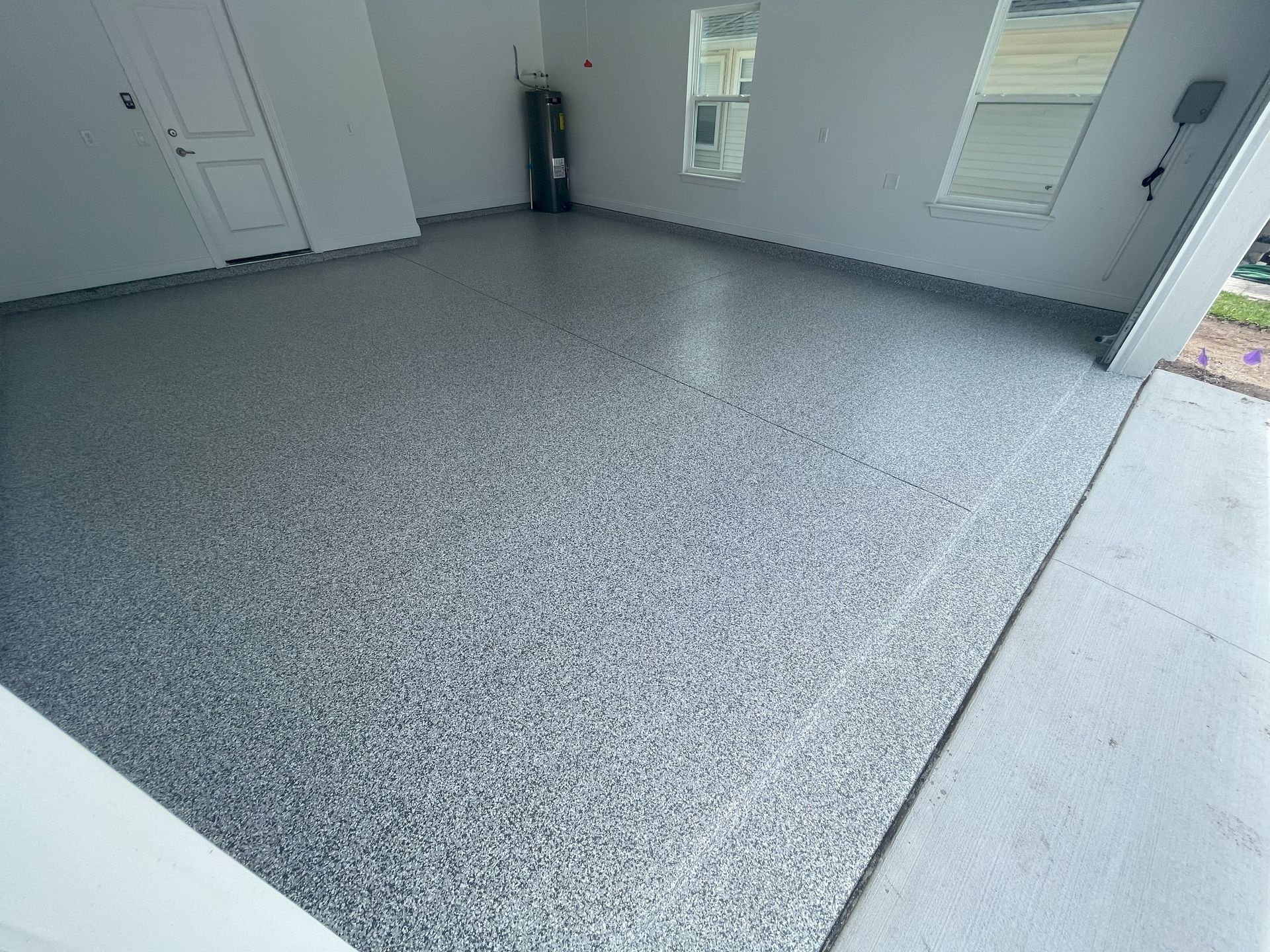 Dark gray colored professional epoxy garage installation for residential home in Jacksonville, Fl. 