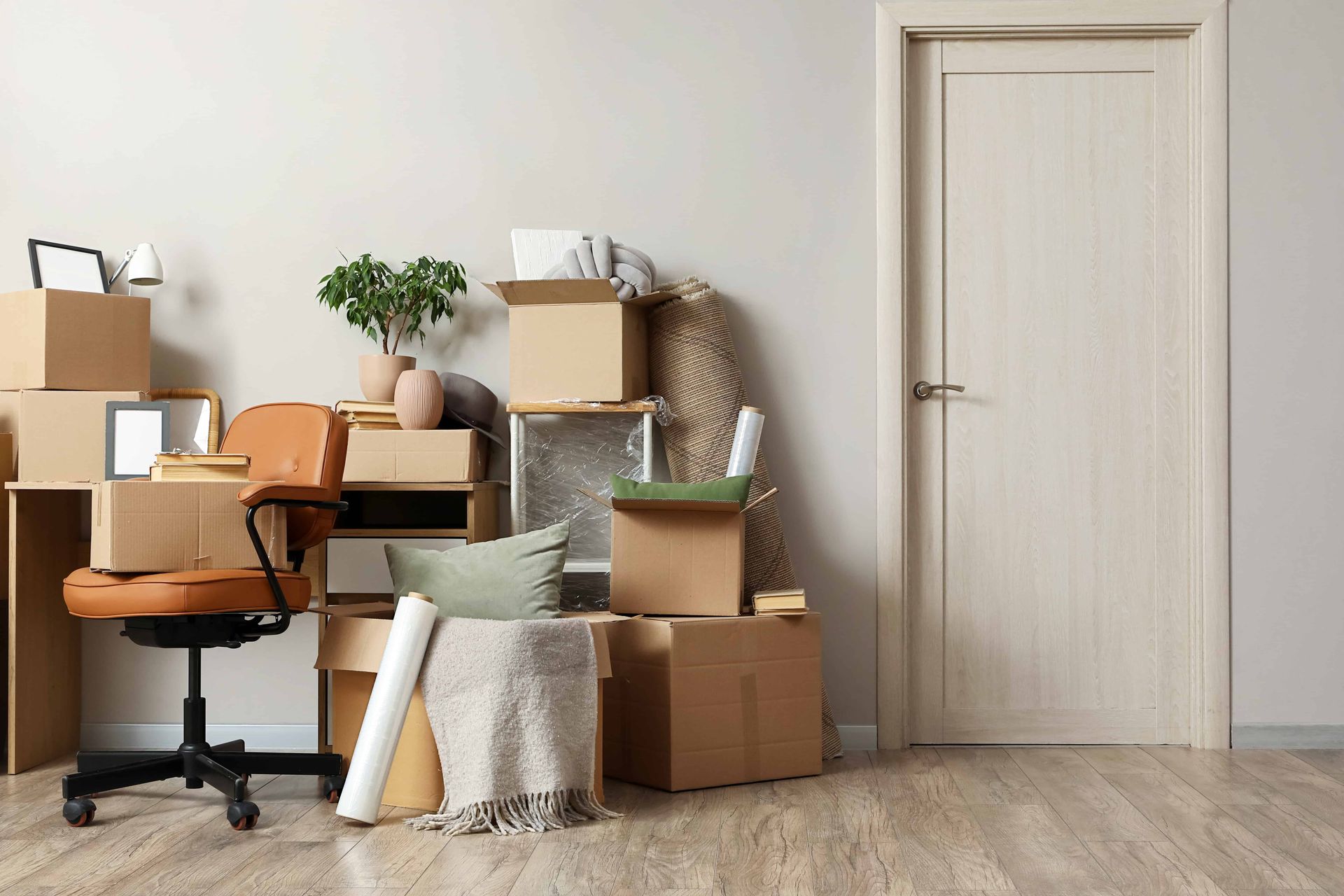 Packed boxes and office chair in a tidy room, suggesting moving or storage preparation