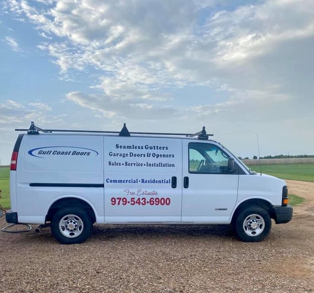 White service van with business logo on side, parked outside.