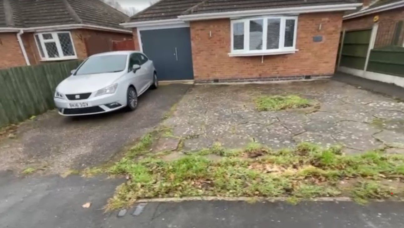 The front of the bungalow before work started, with a worn drive and weeds