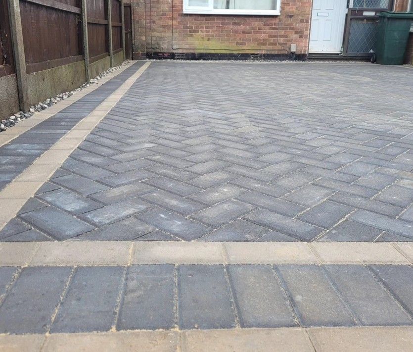 Grey herringbone block paved driveway with a contrasting border, laid by DNA Driveways in Coventry