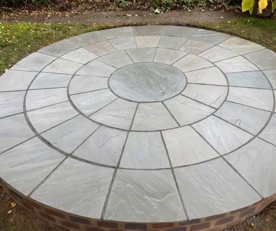 Rings of cut sandstone slabs around a round centre stone