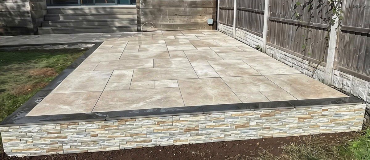 L-shaped raised porcelain patio running back to steps at the house