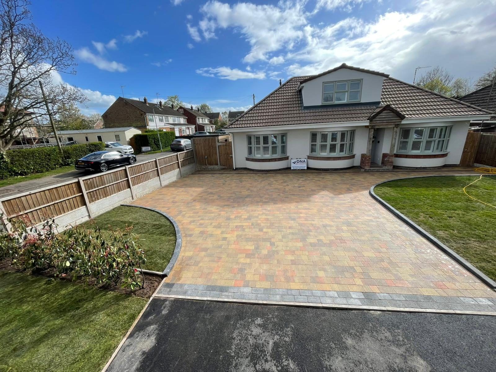 The same multi-tone block paved drive from the side, with curved edges to the lawns on either side
