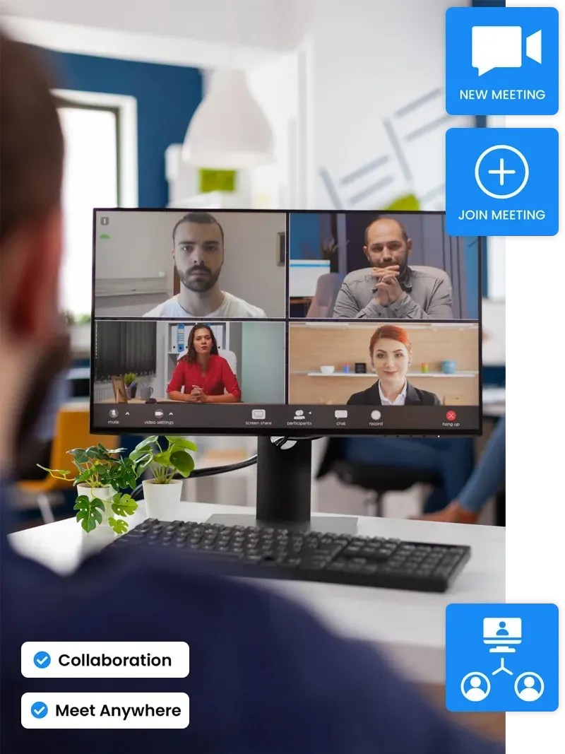 A man is sitting at a desk looking at a computer screen with four people on it.