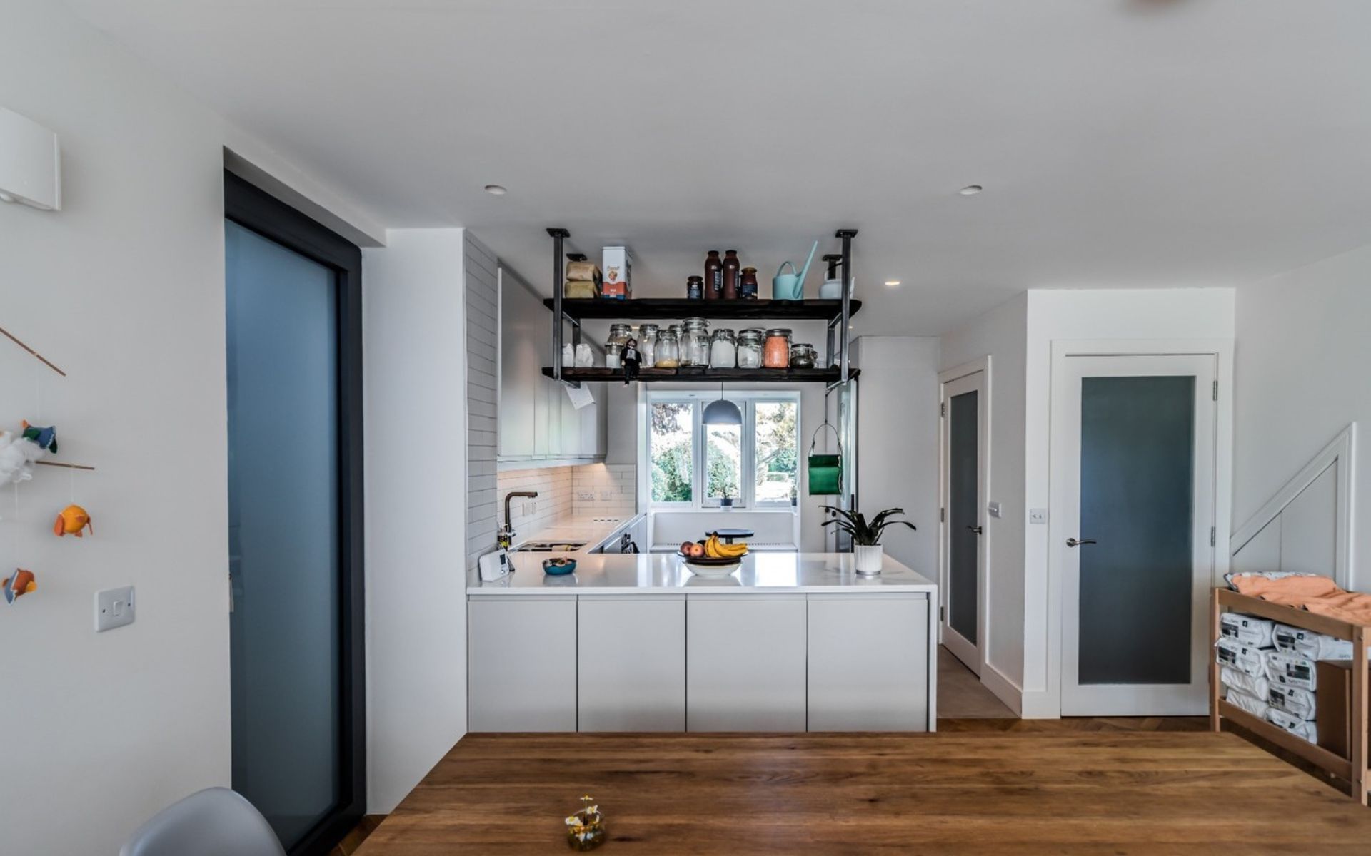 a kitchen with white cabinets and a wooden floor .
