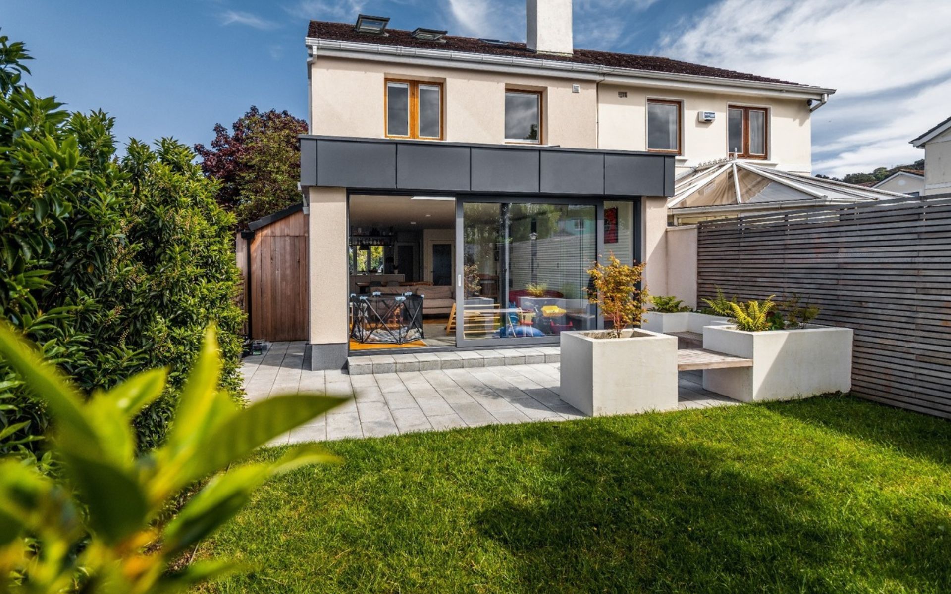 a house with a large sliding glass door and a patio in the backyard .