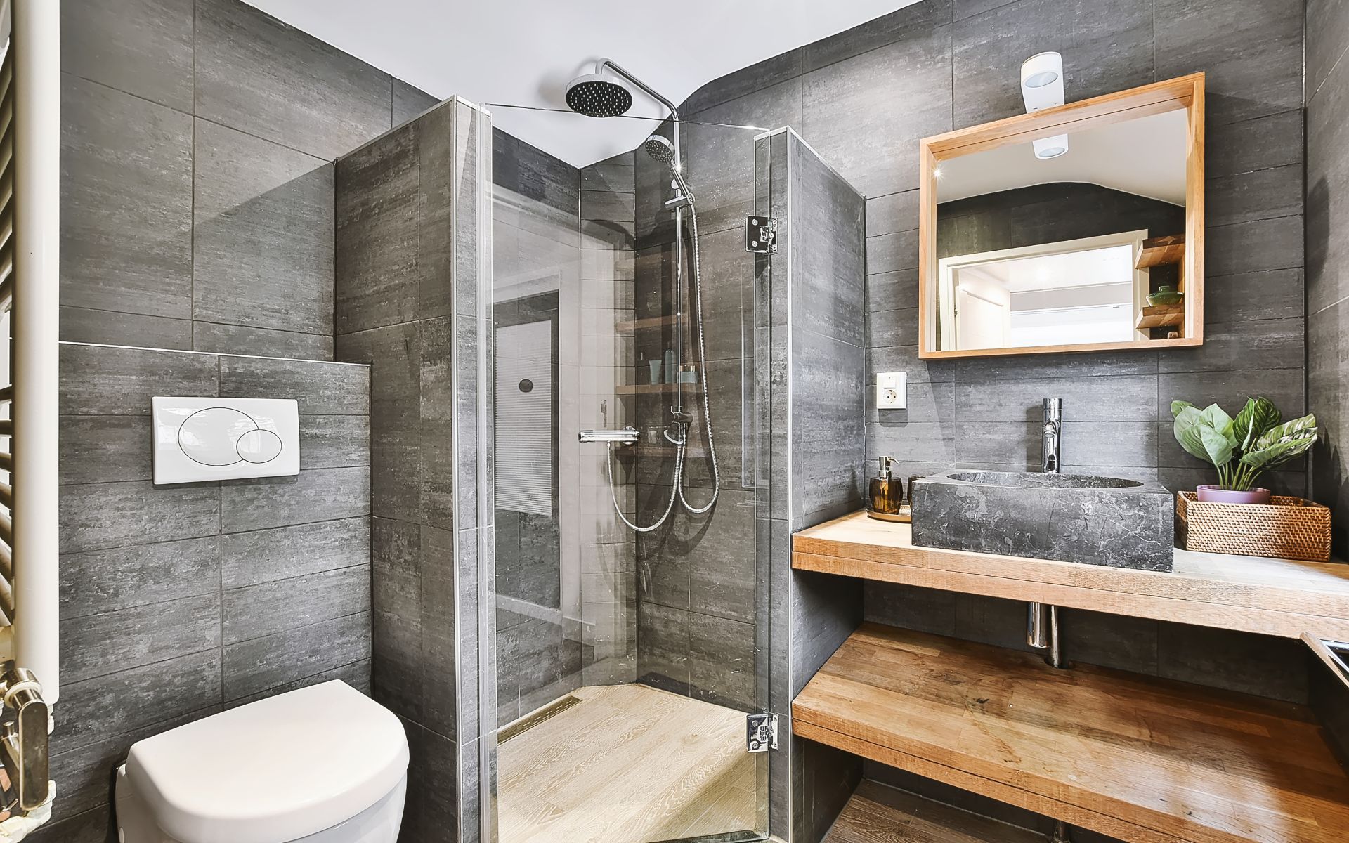 a bathroom with a toilet , sink , shower and mirror .