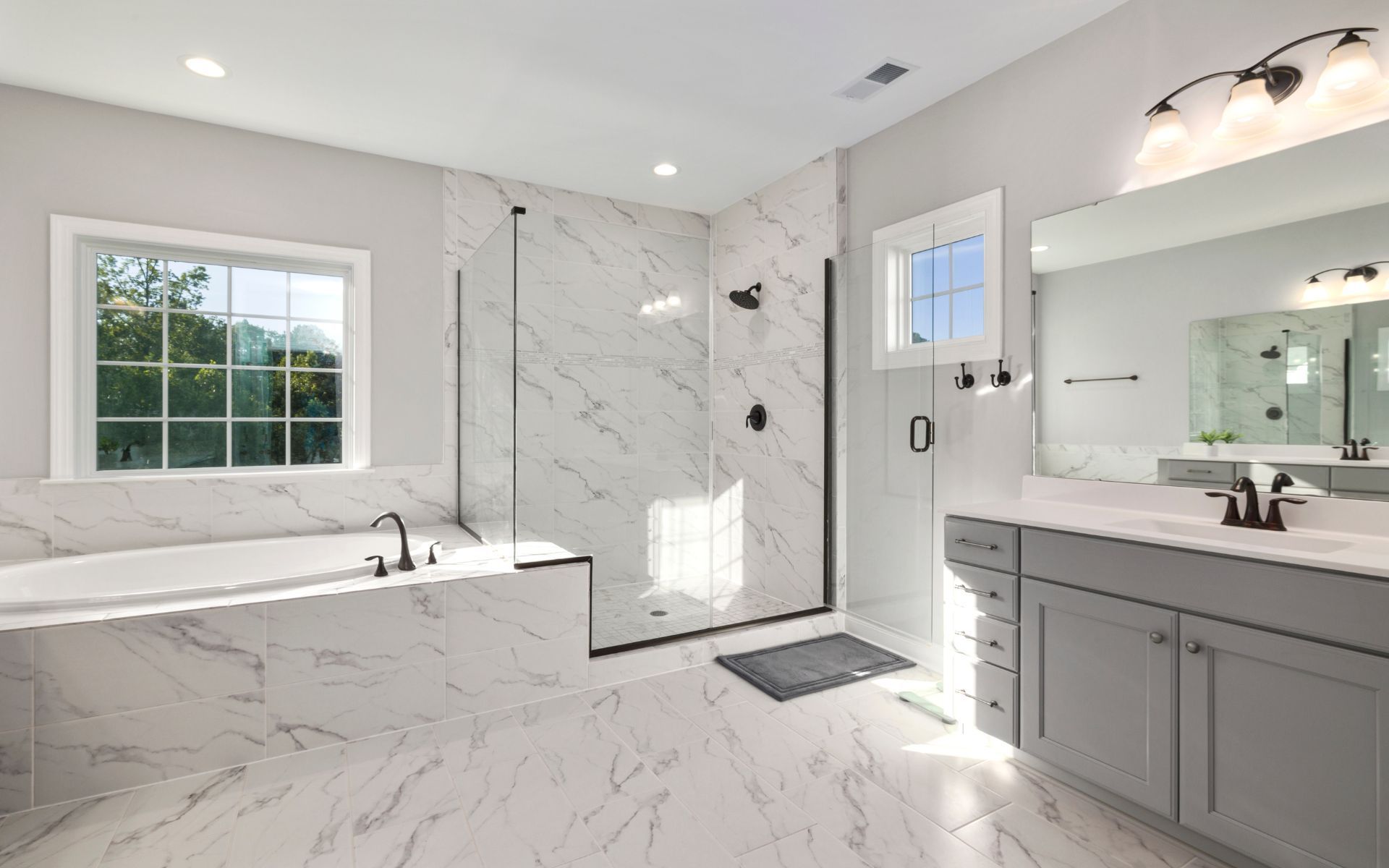 a bathroom with two sinks , a tub , and a walk in shower .