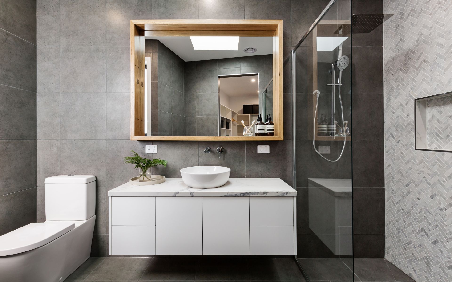 a bathroom with a toilet , sink , mirror and walk in shower .