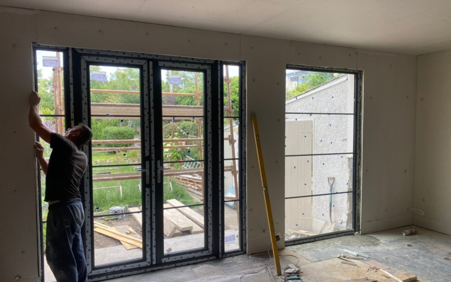 a man is installing a sliding glass door in a room .