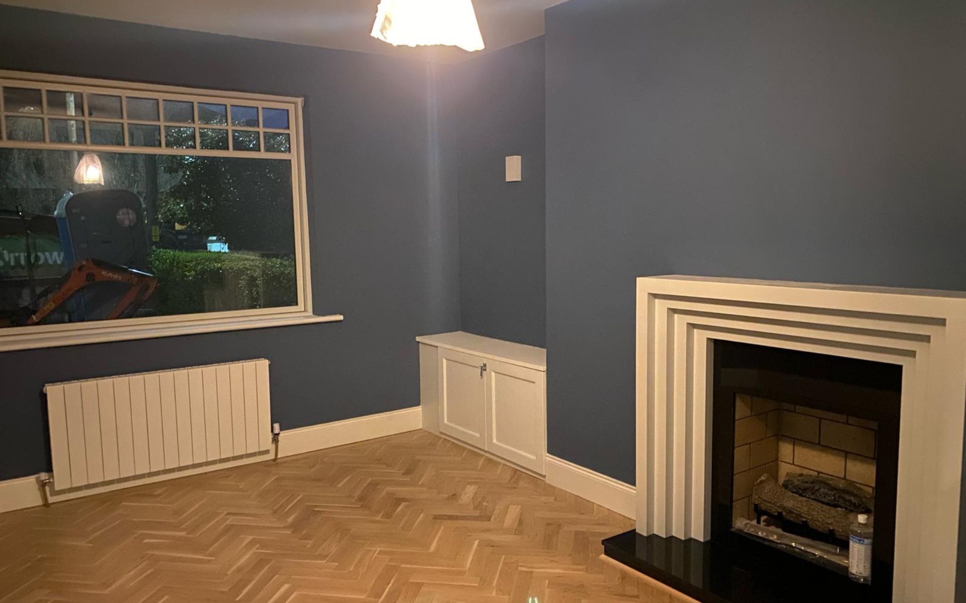 an empty living room with a fireplace and a window .