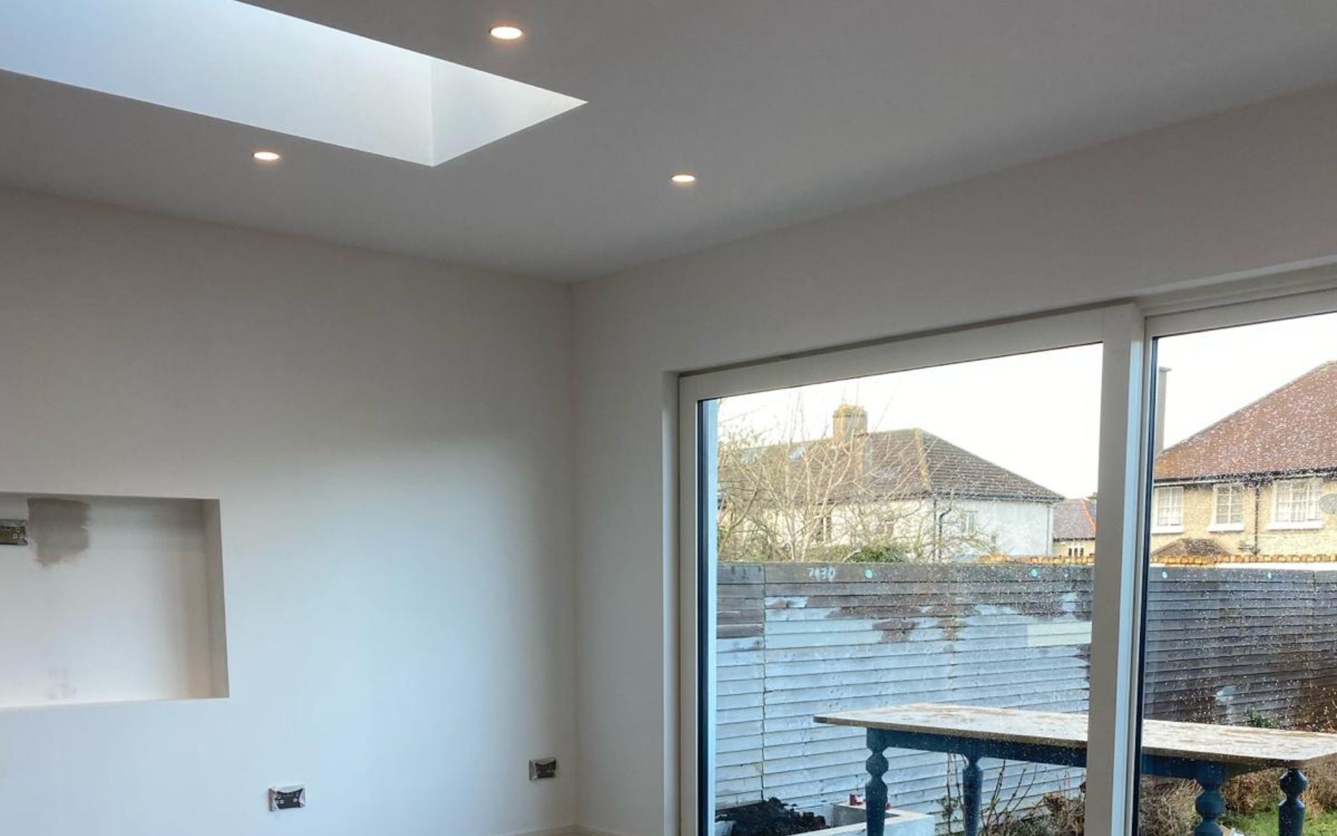 a living room with a sliding glass door and a skylight .