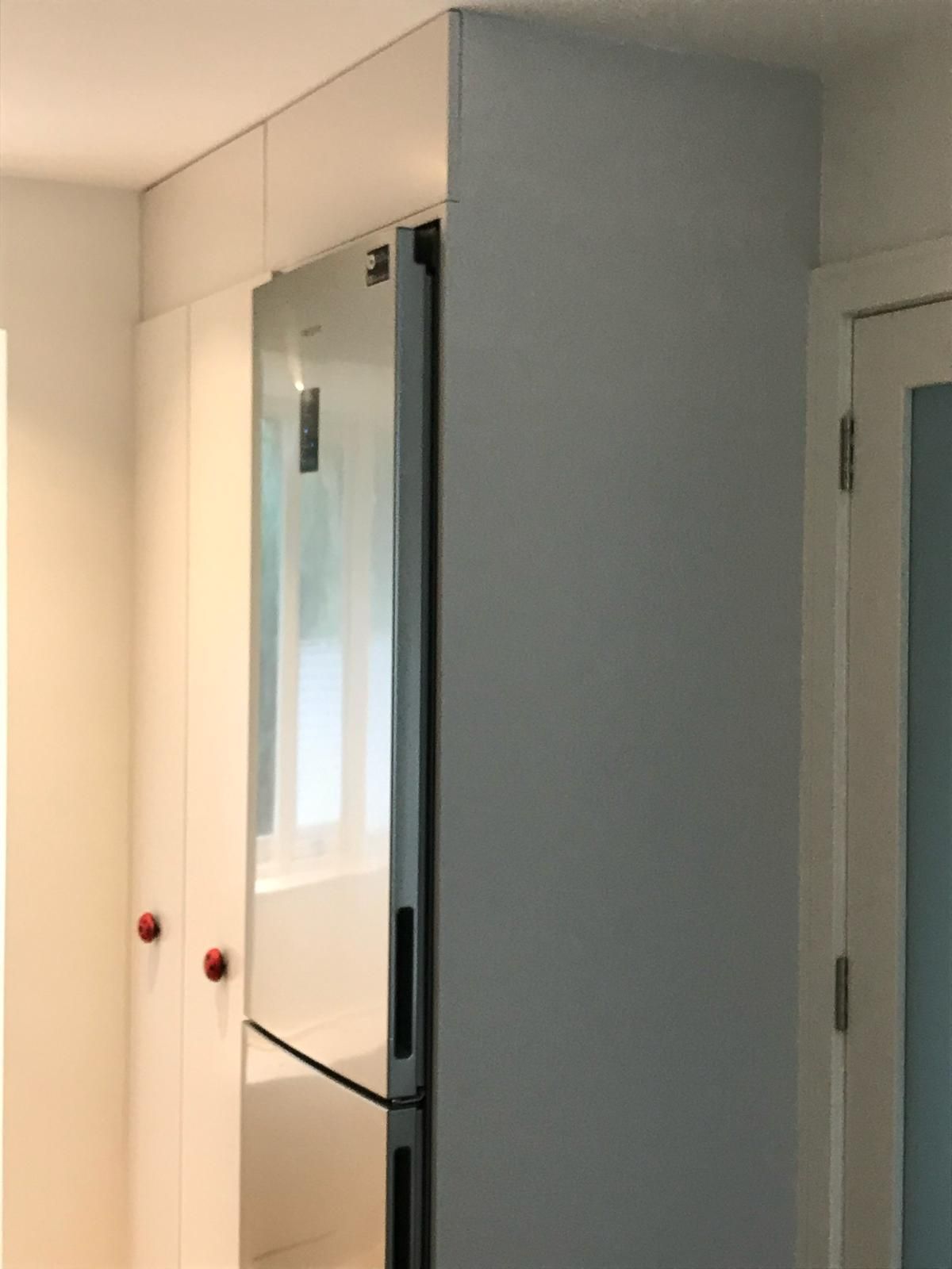 a stainless steel refrigerator in a white cabinet