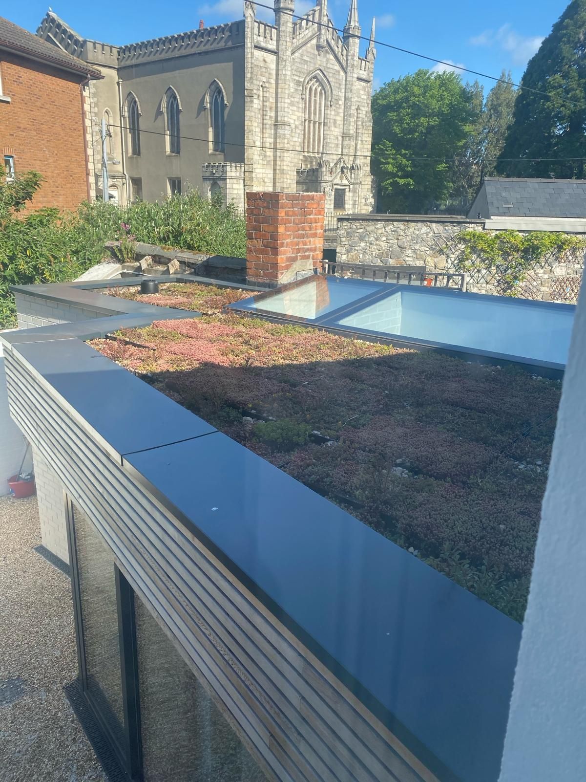 a roof with a green roof and a church in the background .