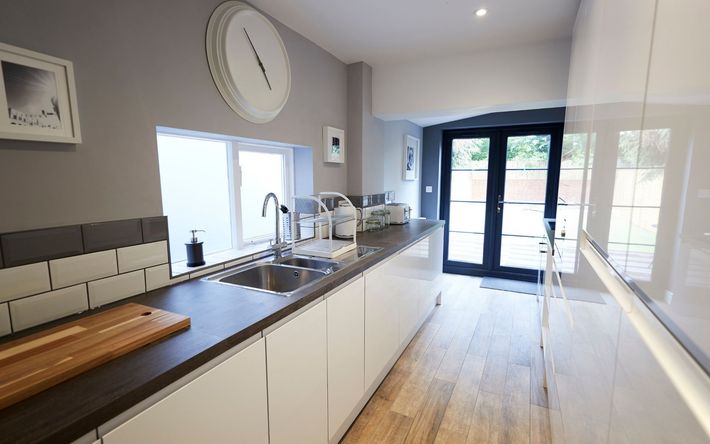 a kitchen with white cabinets and a clock on the wall