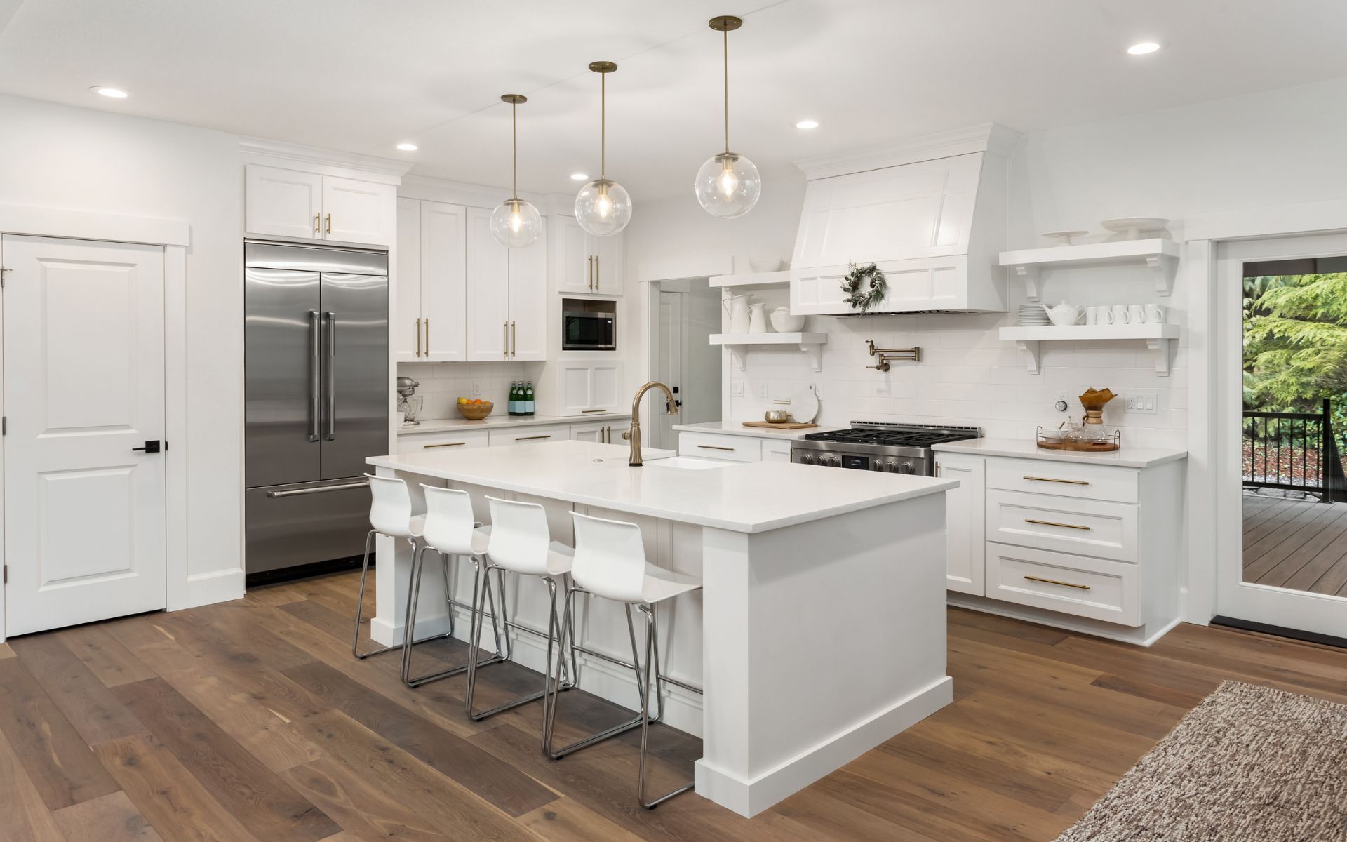 a kitchen with white cabinets and stainless steel appliances and a large island .