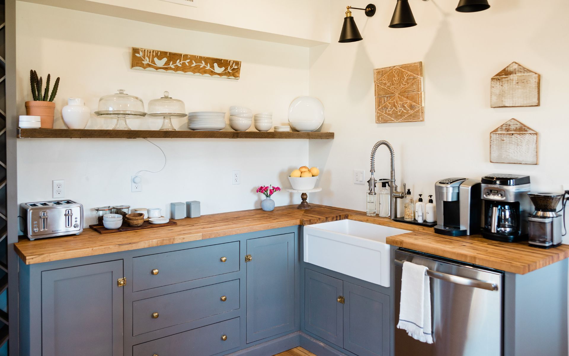 a kitchen with a sink , dishwasher , toaster oven , and coffee maker .