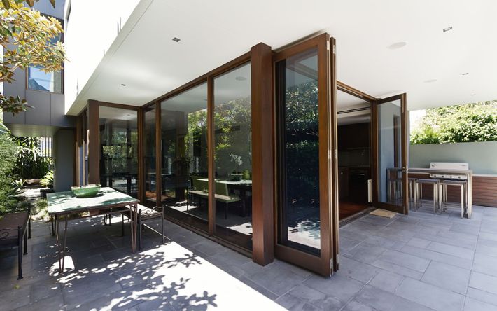 a patio with a table and chairs and a large window