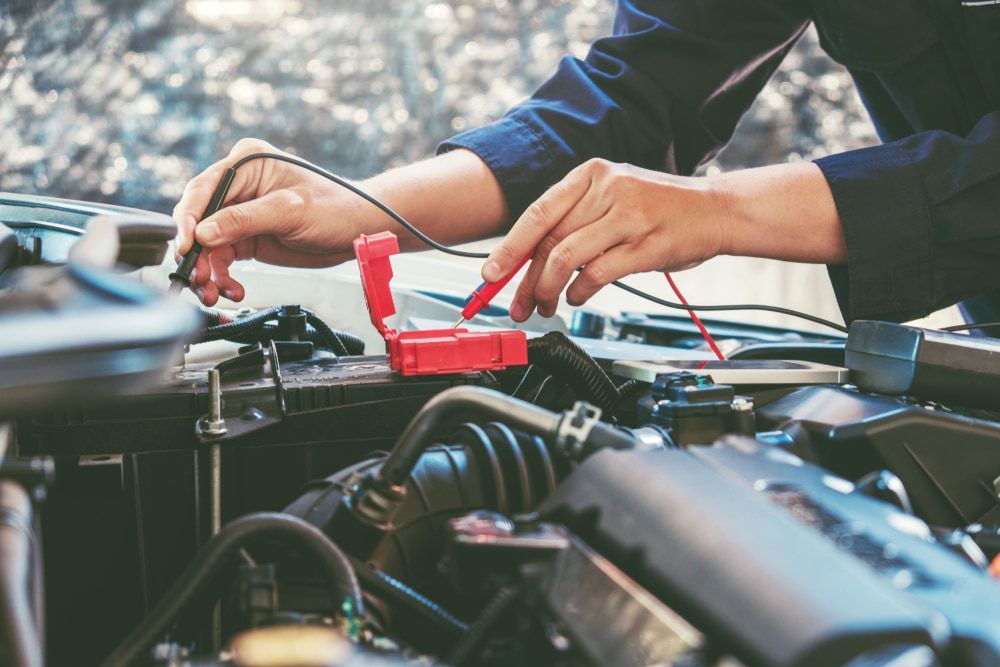 A Man Is Working On The Engine Of A Car — Chris's Automotive & Marine Electrics In Marlow Lagoon, NT