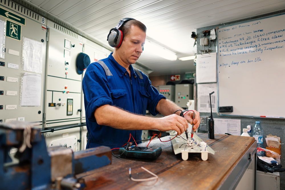 A Man Wearing Headphones Is Working On A Piece Of Equipment — Chris's Automotive & Marine Electrics In Marlow Lagoon, NT