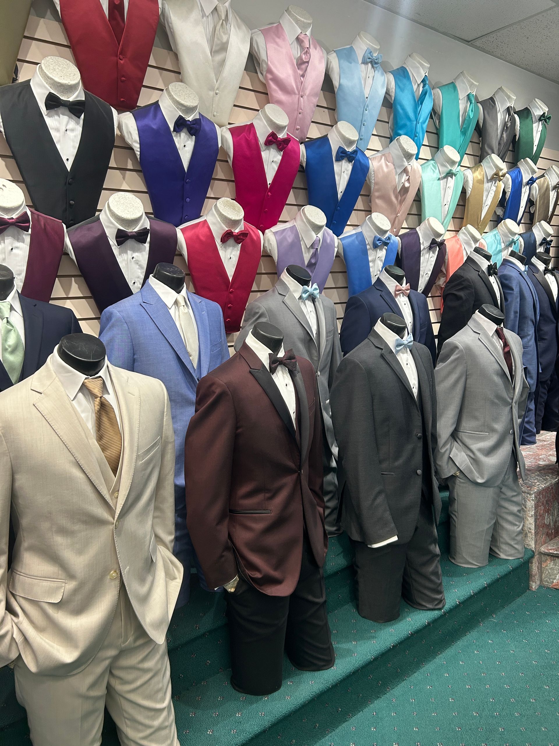Mannequins in colorful suits displayed on shelves in a clothing shop