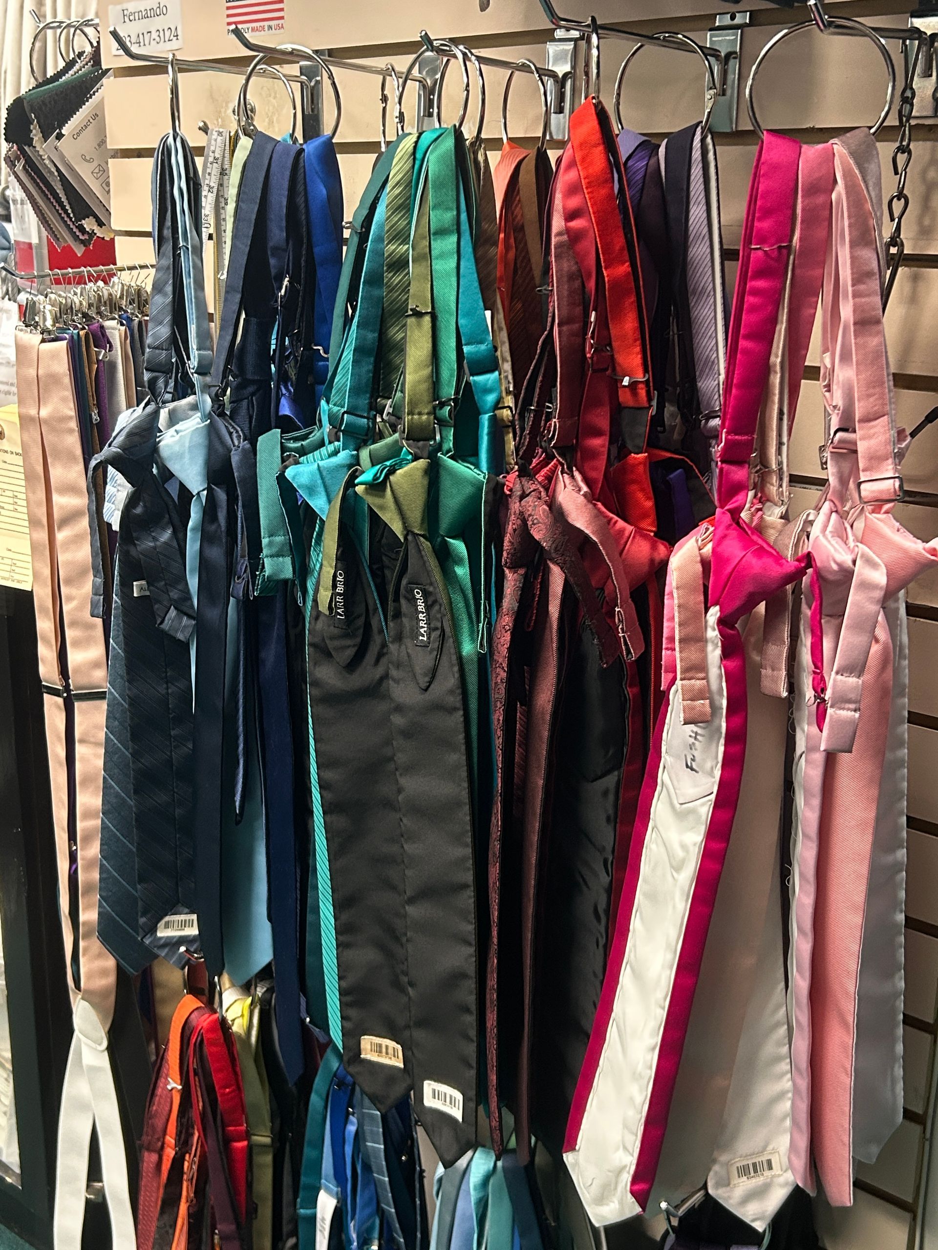 Colorful shiny garment bags hanging on a clothing rack at a market stall