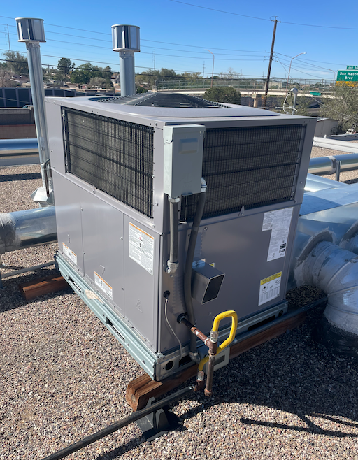 A large air conditioner is sitting on top of a roof.