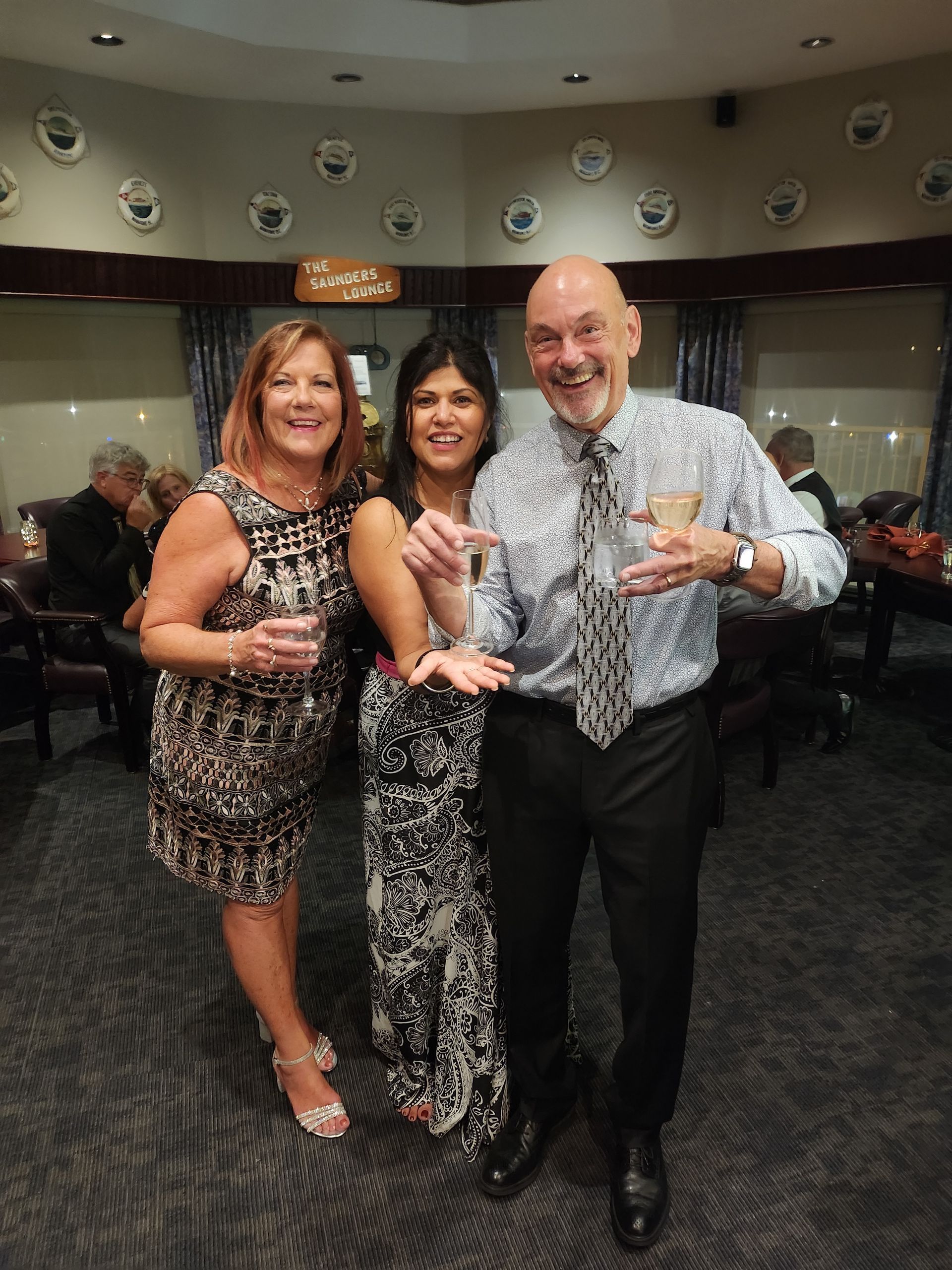A man and two women are posing for a picture in a room.