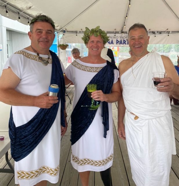 Three men dressed in ancient greek costumes are posing for a picture