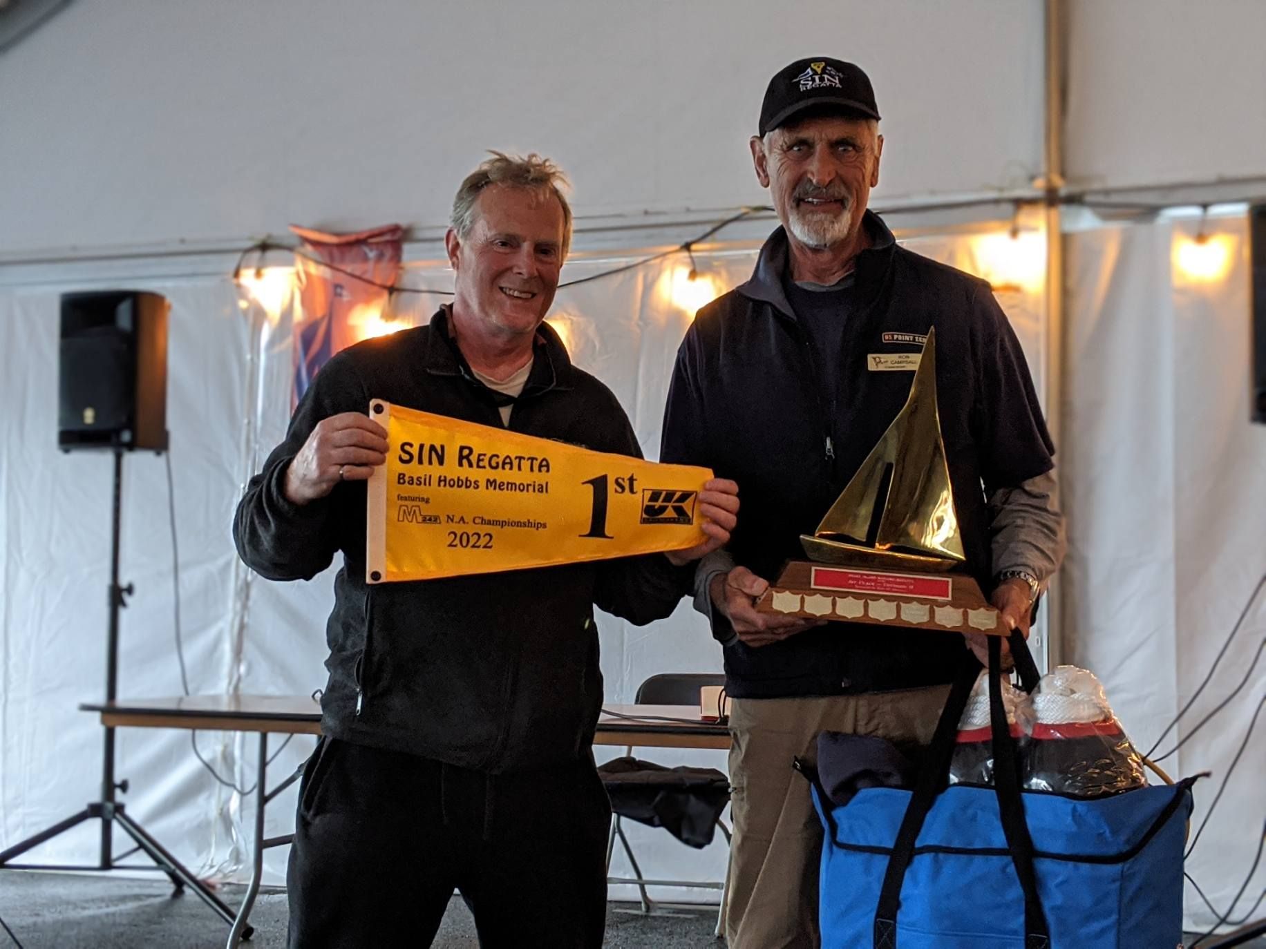 Two men are holding a flag that says 1st on it